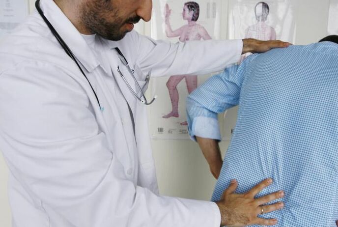 Medico che esamina un paziente con mal di schiena nella regione lombare